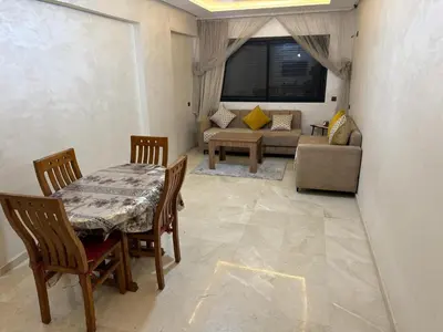 a living room with a table and chairs and a couch at Appartement Nour 5 Marrakech in Marrakech
