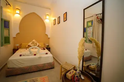 a bedroom with a bed and a mirror at Riad Safran Rouge Jacuzzi RoofTop in Marrakech