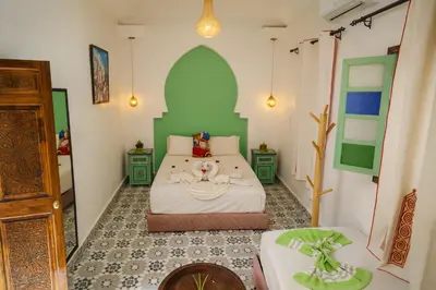 a bedroom with a bed and a table in it at Riad Safran Rouge Jacuzzi RoofTop in Marrakech