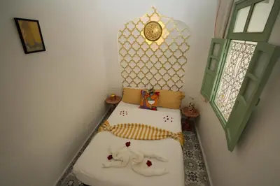 a room with two beds in the corner of a room at Riad Safran Rouge Jacuzzi RoofTop in Marrakech