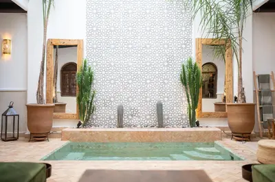 a fountain in the middle of a room with plants at Riad IMPERIA in Marrakech