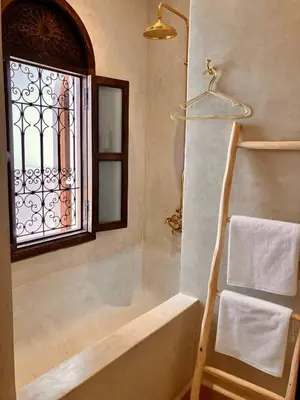 a bathroom with a bath tub and a window at Riad IMPERIA in Marrakech