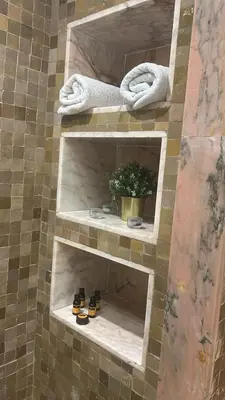 a shower with two shelves in a tiled wall at Palmeraie Village 2 - Cosi appartement en Rez de Jardin in Marrakech