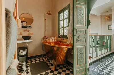 a bathroom with a wooden tub and a window at Le Petit Kenzara & magical rooftop in Marrakech