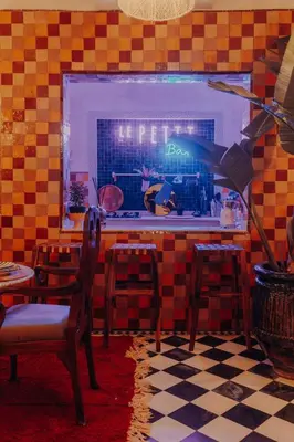 a restaurant with a table and chairs and a window at Le Petit Kenzara & magical rooftop in Marrakech
