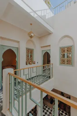 an ornate staircase in a home with white walls and a ceiling at Le Petit Kenzara & magical rooftop in Marrakech