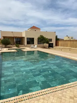 a large swimming pool in front of a house at Villa 5 chambres route de Casablanca Marrakech in Marrakech