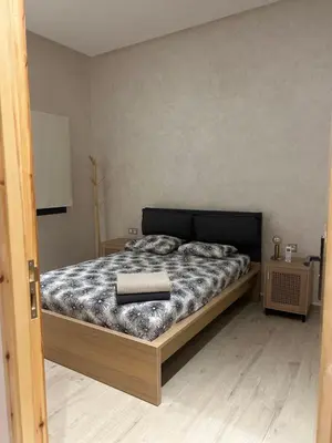 a bedroom with a bed with a black and white comforter at Villa 5 chambres route de Casablanca Marrakech in Marrakech