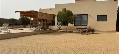 a patio with chairs and a table in front of a building at Villa 5 chambres route de Casablanca Marrakech in Marrakech
