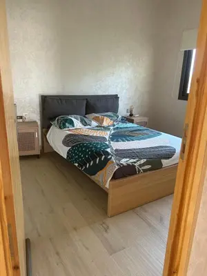 a bed with a wooden frame in a bedroom at Villa 5 chambres route de Casablanca Marrakech in Marrakech