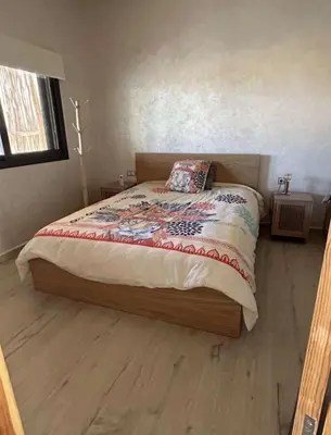a bedroom with a bed with a wooden floor at Villa 5 chambres route de Casablanca Marrakech in Marrakech