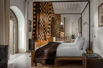 a bedroom with a large bed and a table at Riad Jaaneman in Marrakech
