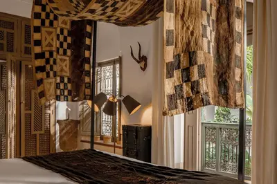 a bedroom with a bed with curtains and a window at Riad Jaaneman in Marrakech