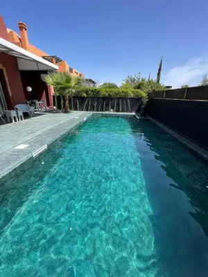 a swimming pool with blue water in a house at La Villa 2A, Palmeraie, Marrakech in Marrakech