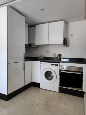 a kitchen with a washing machine and white cabinets at Plein centre Marrakech, grand balcon filant in Marrakech