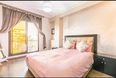 a bedroom with a large bed with a large window at Superbe appartement en plein centre à Gueliz in Marrakech