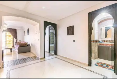 a large living room with white walls and arched windows at Superbe appartement en plein centre à Gueliz in Marrakech