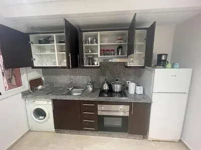 a kitchen with a refrigerator and a stove and a sink at Superbe appartement en plein centre à Gueliz in Marrakech