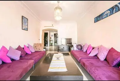 a living room with pink and purple pillows on couches at Superbe appartement en plein centre à Gueliz in Marrakech