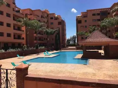 a swimming pool in front of some buildings at appartment avec piscine in Marrakech