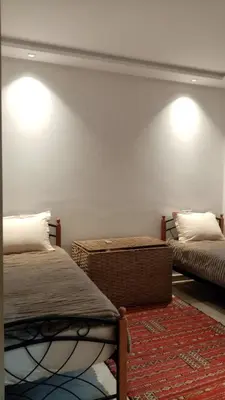 a bedroom with two beds and a rug at appartment avec piscine in Marrakech