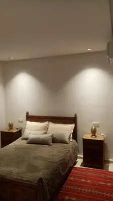 a bedroom with a large bed with two night stands at appartment avec piscine in Marrakech