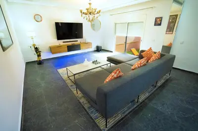 a living room with a couch and a tv at Villa zéphyr in Marrakech