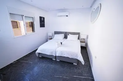 a bedroom with a bed with white sheets and pillows at Villa zéphyr in Marrakech