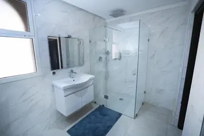 a white bathroom with a sink and a shower at Villa zéphyr in Marrakech