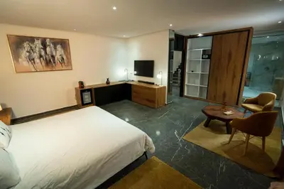 a bedroom with a bed and a desk with a television at Villa zéphyr in Marrakech