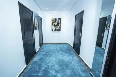 a hallway with black doors and a blue carpet at Villa zéphyr in Marrakech