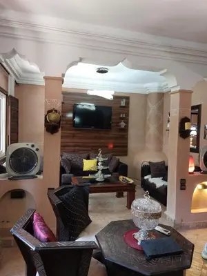a living room with a couch and a tv at Riad Habib - Traditional Moroccan 3 bedroom family home in Marrakech