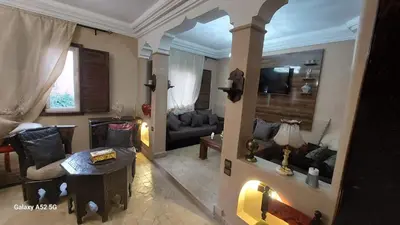 a living room with a couch and a table at Riad Habib - Traditional Moroccan 3 bedroom family home in Marrakech