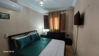 a bedroom with a bed with blue pillows and a television at Riad Habib - Traditional Moroccan 3 bedroom family home in Marrakech