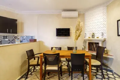 a dining room with a wooden table and chairs at Riad AJI 4 Rooms, Pool, Internet, Top Emplacement Médina in Marrakech