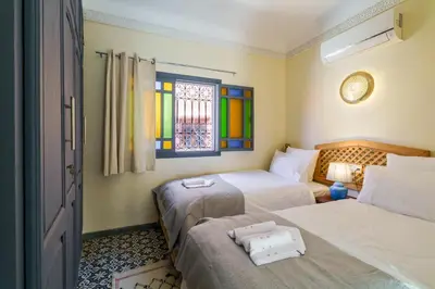 a bedroom with two beds and a stained glass window at Riad AJI 4 Rooms, Pool, Internet, Top Emplacement Médina in Marrakech