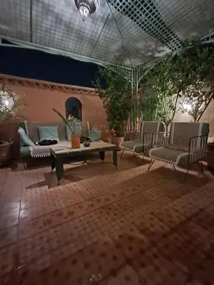 a patio with couches and a table and chairs at Riad El Badii chambre queen size Badii in Marrakech