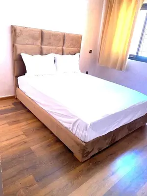 a large bed in a bedroom with a wooden floor at Modern 3-Bedroom apartment with Balcony-Central Gueliz Marrakech in Marrakech