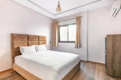 a bedroom with a large bed and a window at Modern 3-Bedroom apartment with Balcony-Central Gueliz Marrakech in Marrakech
