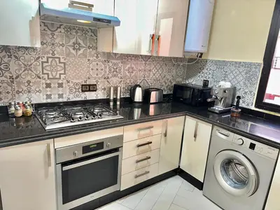 a kitchen with a stove and a washing machine at Modern 3-Bedroom apartment with Balcony-Central Gueliz Marrakech in Marrakech