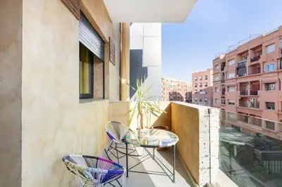a balcony with two chairs and a table on a building at Modern 3-Bedroom apartment with Balcony-Central Gueliz Marrakech in Marrakech