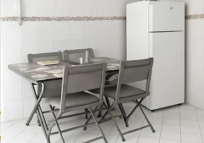 a kitchen table with four chairs and a refrigerator at Marrakech Appart in Marrakech