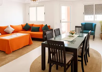 a living room with an orange couch and a dining table at Marrakech Appart in Marrakech