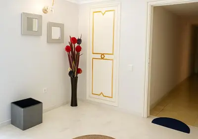 a vase of flowers in a room with a door at Marrakech Appart in Marrakech
