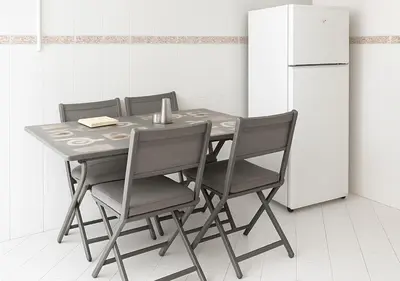 a dining room table with four chairs and a refrigerator at Marrakech Appart in Marrakech