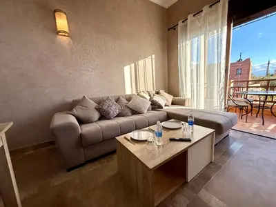 a living room with a couch and a table at Beach Mama Waky Marrakech Appartement Premium Piscine & Vue Atlas in Marrakech