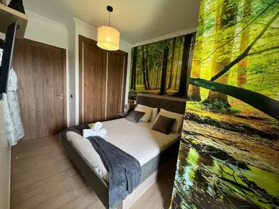 a bedroom with a bed and a painting of a forest at Splendido appartamento a Gueliz in Marrakech