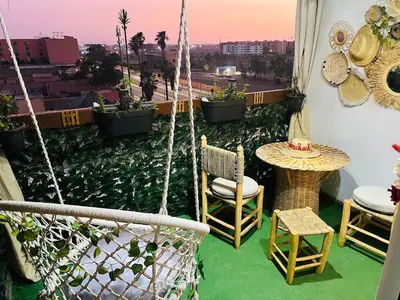 a balcony with a hammock and a table and chairs at Splendido appartamento a Gueliz in Marrakech