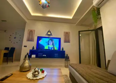 a living room with a tv and a couch and a table at Splendido appartamento a Gueliz in Marrakech