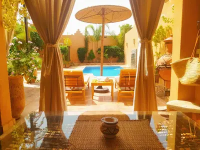 a living room with a glass table and a pool at Villa brek in Marrakech
